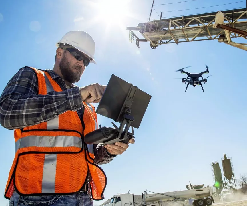 construction worker flying drone on construction site