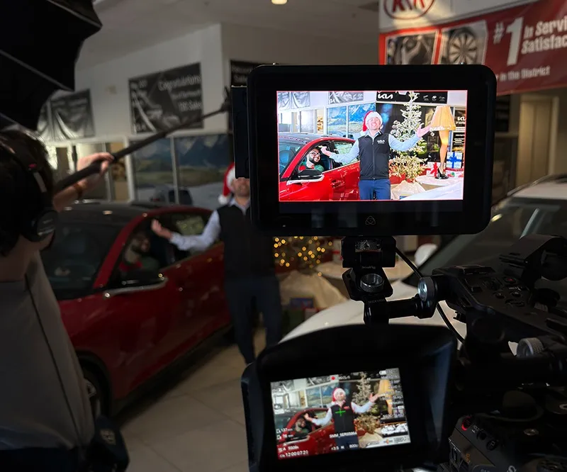 Female videographer taking video of a film set with an actor