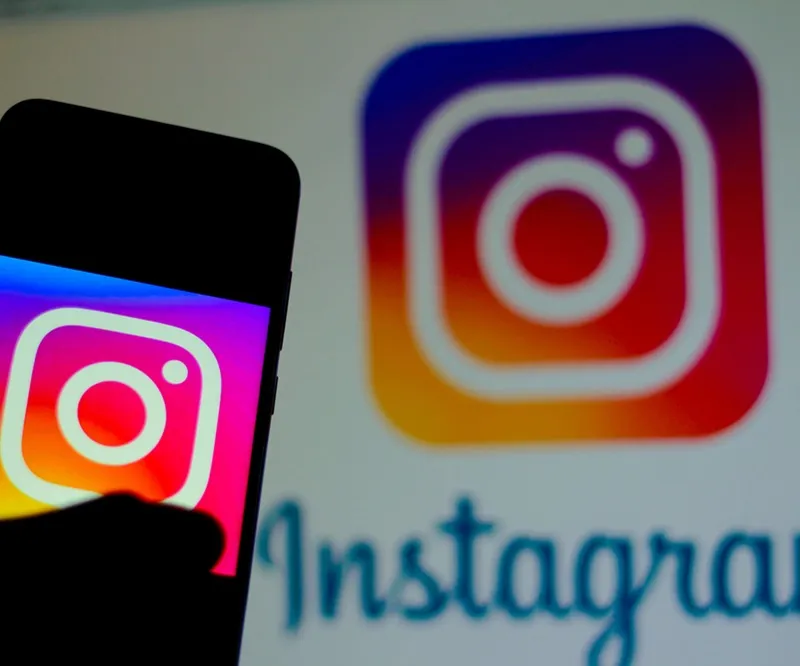 Instagram logo overlayed onto a mobile phone and laptop with a marketing type feel around it