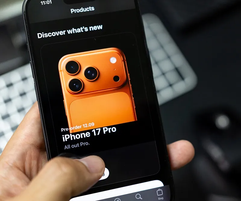 person browsing the internet on their phone looking to preorder an orange iphone 17