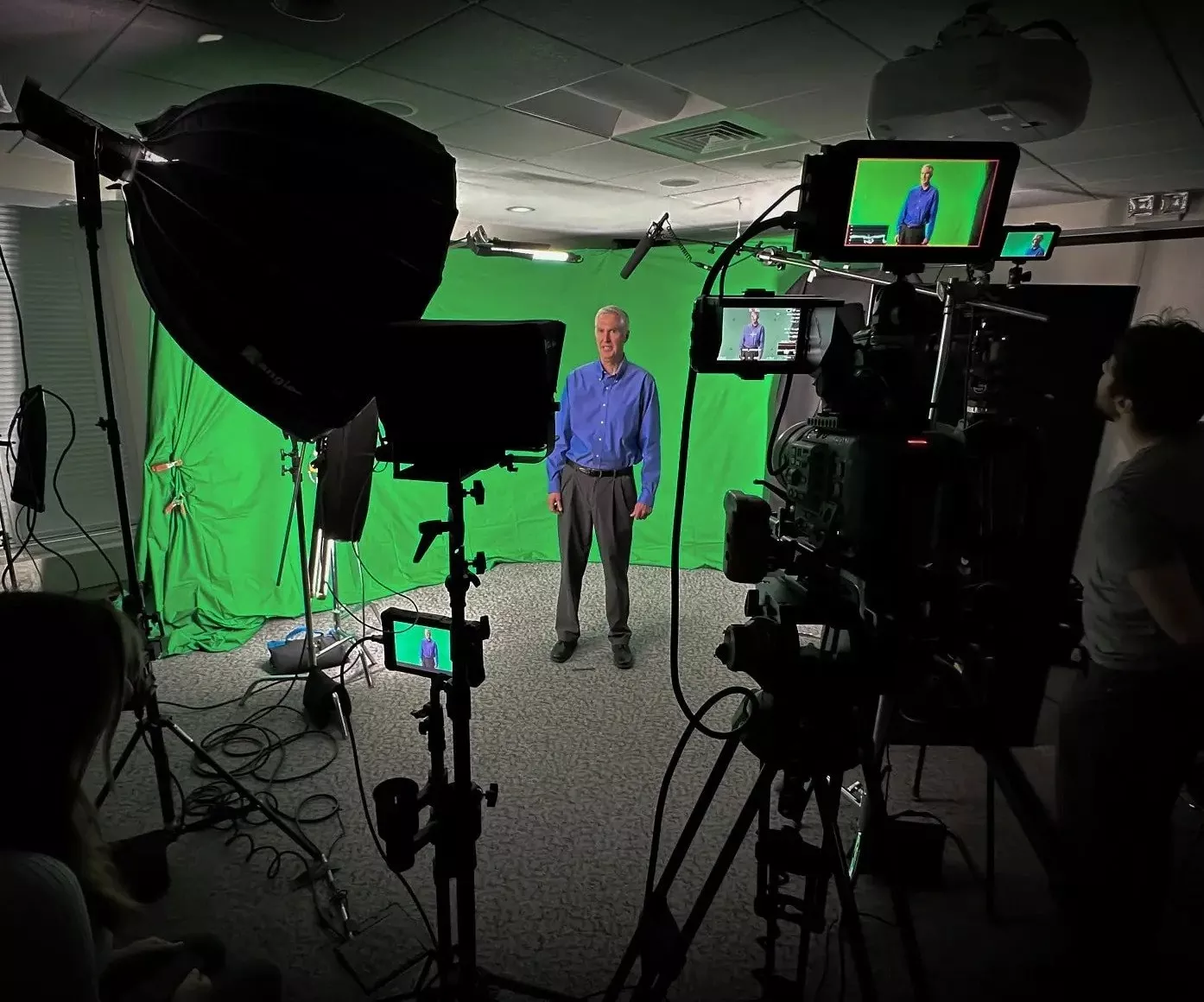 Man standing in front of a green screen on camera